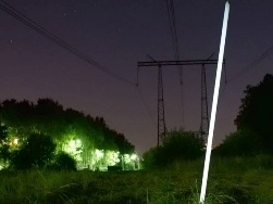 Люминесцентная лампа, светящаяся под воздушной линией электропередачи